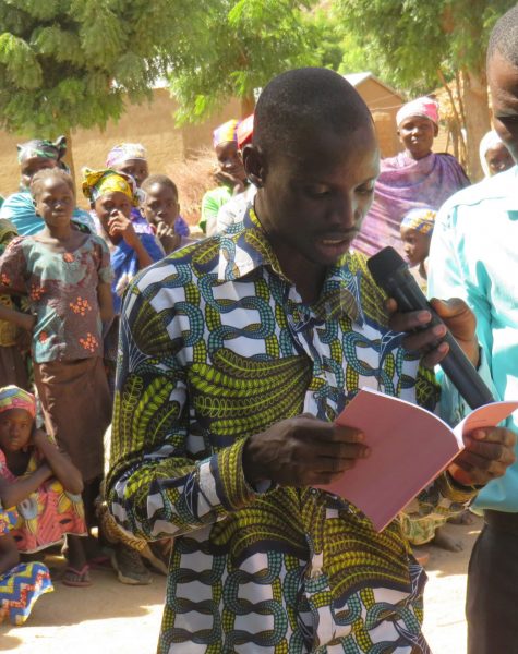 A Mada young man reading a portion of the book of Luke